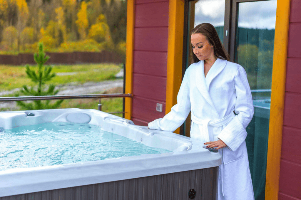 Screenshot-2022-04-27-at-12.30.50 | GFD Homes square hot tub: Lady wearing gown =, leaning over bubbling hot tub.