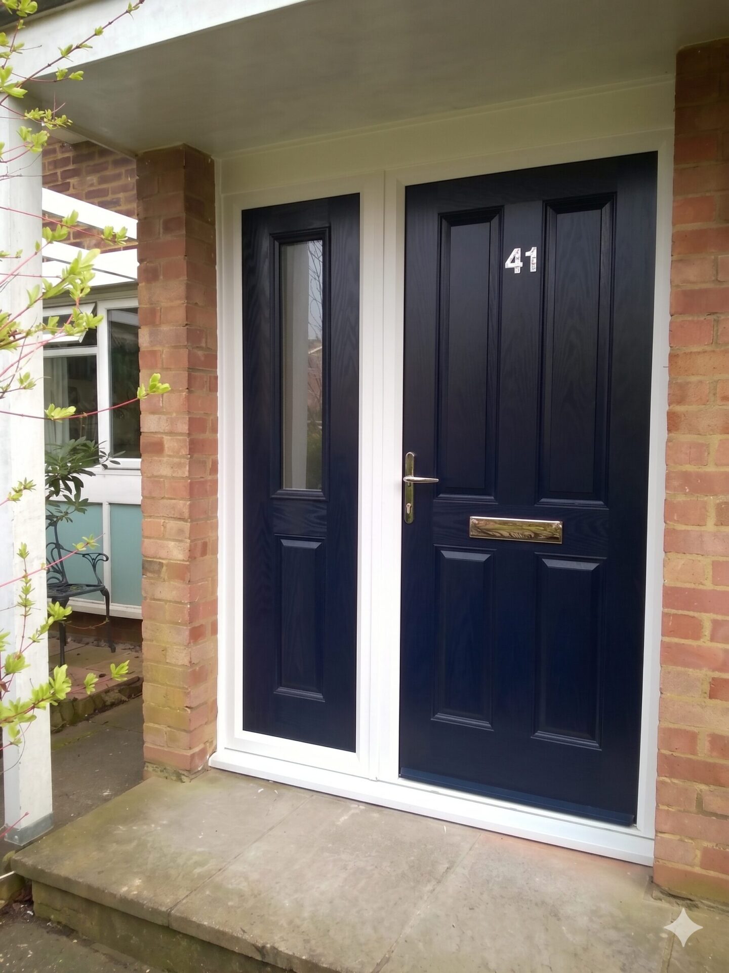Gemini_Generated_Image_b9hywrb9hywrb9hy | GFD Homes GFD Homes Navy-blue double front doors on a brick porch, with a brass handle and mail slot; house number 41 visible on the right door.