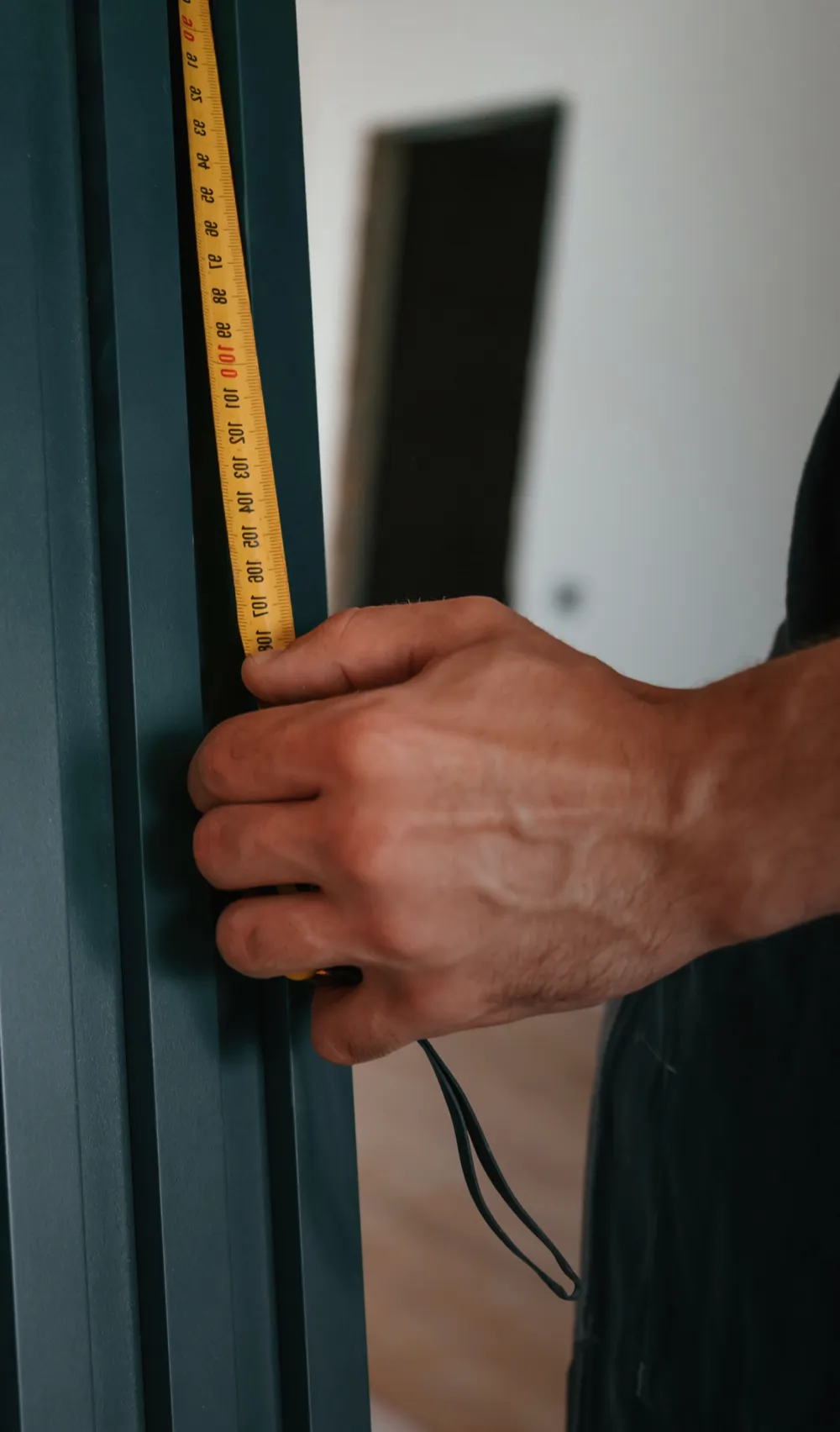 Installer measuring a door frame with a tape measure