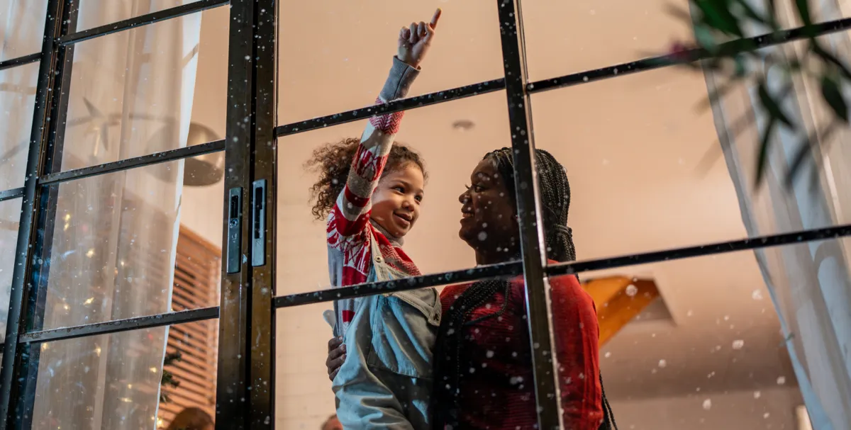 A woman and child looking out of a window with toughened safety glass